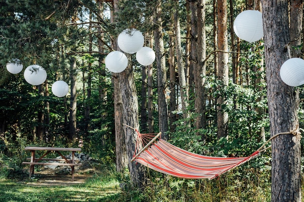 Hamaca en los árboles con adornos de globos blancos