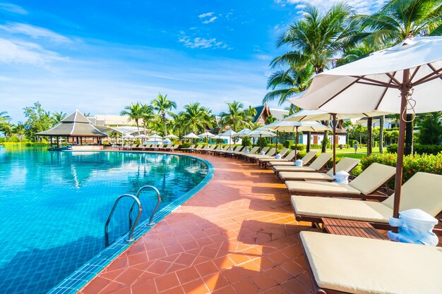 Hamacas y sombrillas puestas cercas de una piscina grande