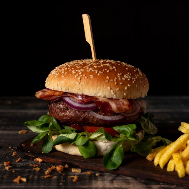 Hamburguesa de alto ángulo con papas fritas en la mesa