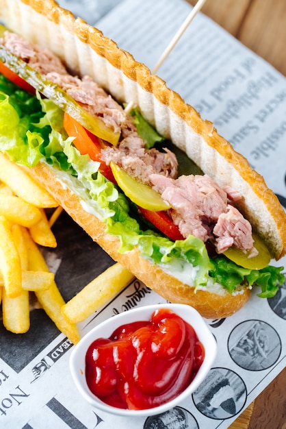 Hamburguesa de atún servida con papas fritas y salsa de tomate