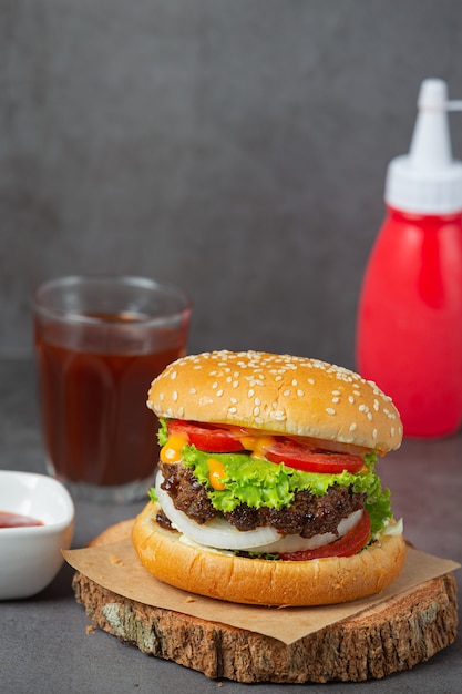 Hamburguesa con carne frita, tomates, encurtidos, lechuga y queso.