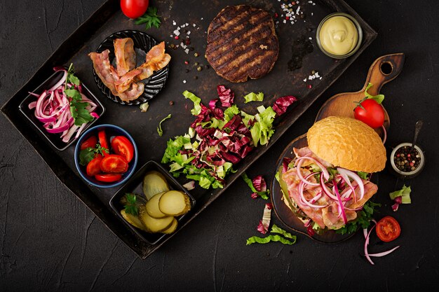 hamburguesa con carne de res, tomate, pepino en vinagre y tocino frito.