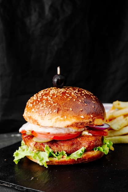 Hamburguesa con carne, tomate y lechuga en un bollo.