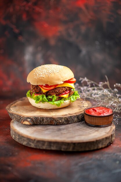 Hamburguesa de carne de vista frontal con ensalada de queso y tomates en el escritorio oscuro sándwich de pan de comida rápida