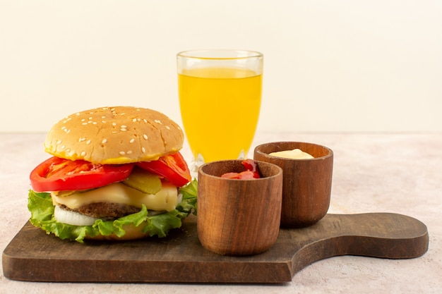 Una hamburguesa de carne de vista frontal con queso y ensalada verde junto con ketchup y mostaza en la mesa de madera