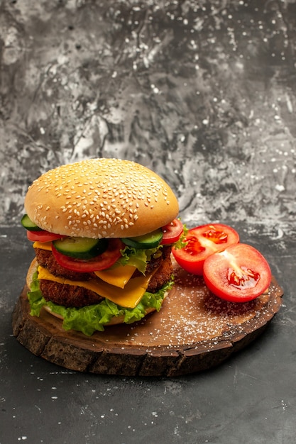 Hamburguesa de carne de vista frontal con verduras y queso en una superficie oscura pan sándwich de comida rápida