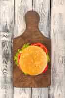 Foto gratuita una hamburguesa de carne de vista superior con queso y ensalada verde