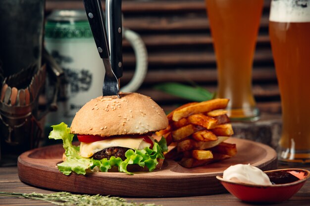 Hamburguesa clásica con papas fritas y cerveza.