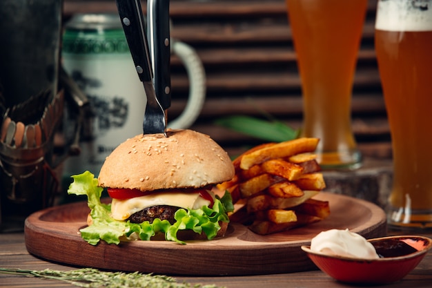 Hamburguesa clásica con papas fritas y cerveza.