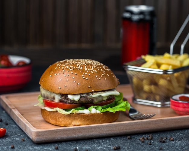 Hamburguesa con cotlet, verduras y salsa de mayonesa.