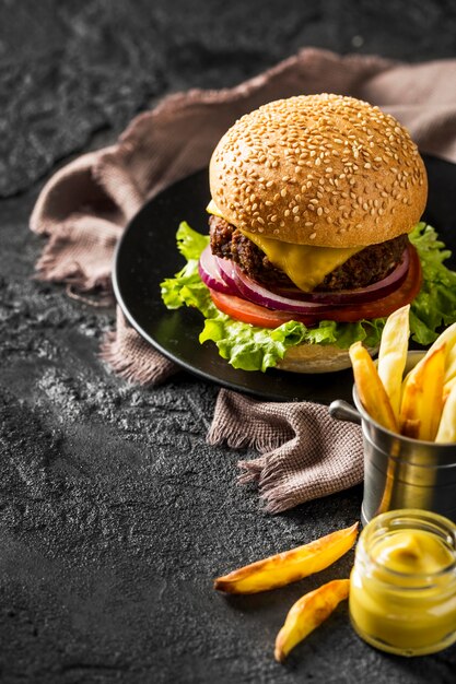 Hamburguesa fresca de alto ángulo, papas fritas y salsa