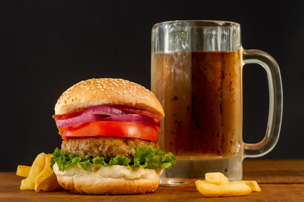 Hamburguesa fresca con papas fritas y jarra de cerveza