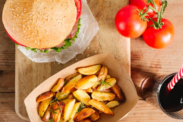 Hamburguesa y fritadas del primer de la vista superior en el tablero de madera