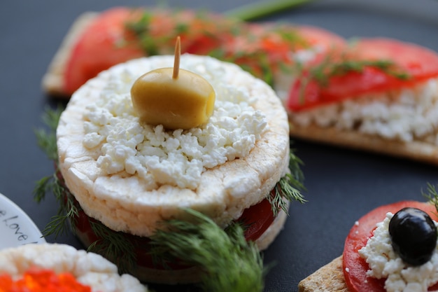 Hamburguesa de galleta con ricotta, eneldo, tomate y aceitunas.