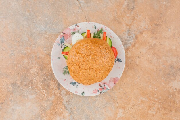 Hamburguesa grande con pepino y huevo.