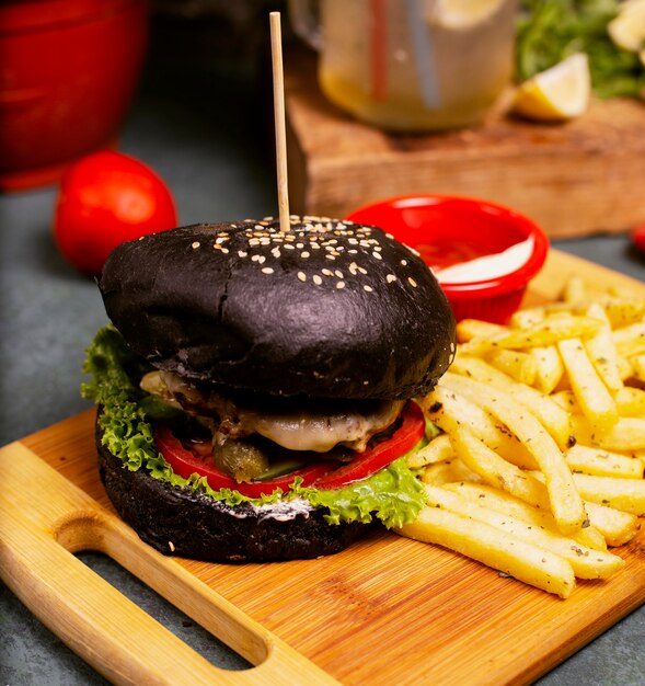 Hamburguesa negra de chocolate con queso, carne, hamburguesa con verduras, comida rápida, papas fritas y salsa de tomate.