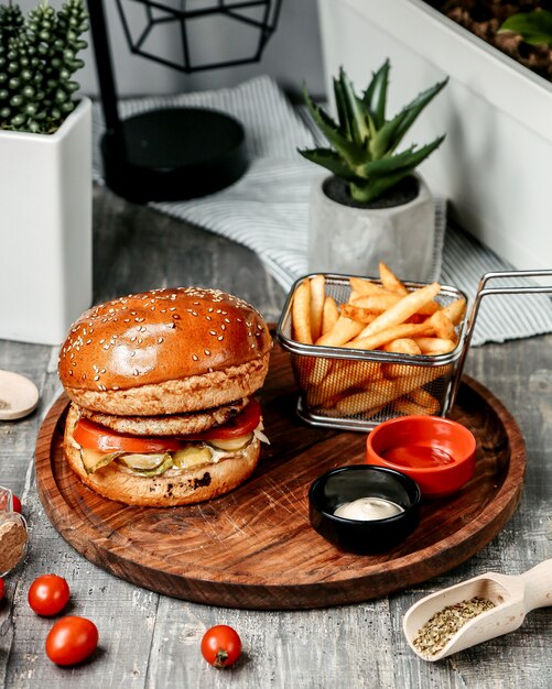 Hamburguesa con papas fritas en el escritorio de madera