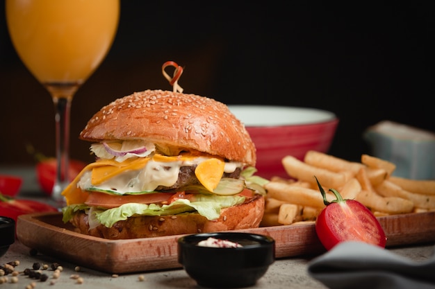 Hamburguesa con papas fritas y jugo de naranja.