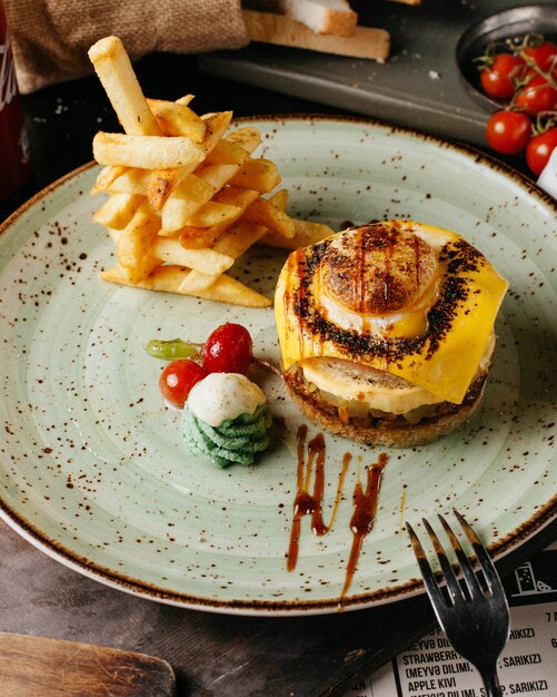 hamburguesa con papas fritas y tomates en un plato