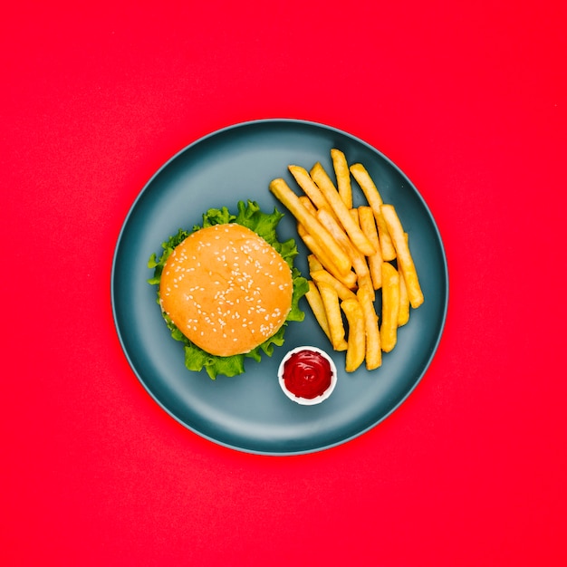 Hamburguesa plana y papas fritas en un plato