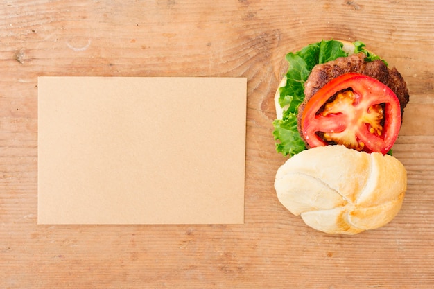 Foto gratuita hamburguesa plana sobre pizarra con cartón.