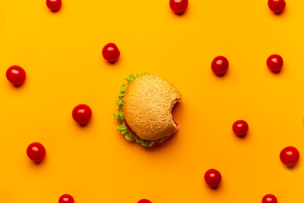 Foto gratuita hamburguesa plana con tomates cherry.
