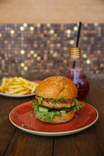 Hamburguesa de pollo con pepino fresco y encurtido, lechuga y salsa de tomate