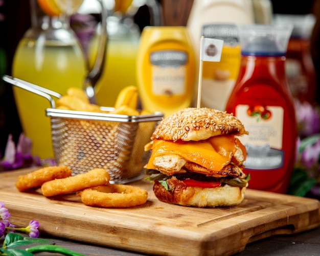 Hamburguesa de pollo con queso cheddar servido con papas fritas y salsa