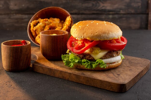 Una hamburguesa de pollo vista frontal con queso y ensalada verde en el escritorio de madera y comida rápida de sándwich