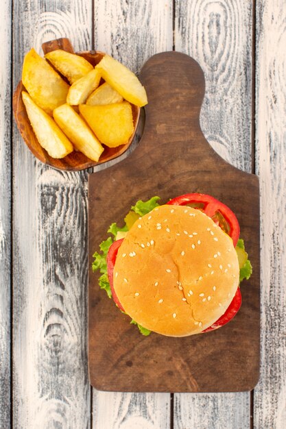 Una hamburguesa de pollo de vista superior con queso y papas ensalada verde