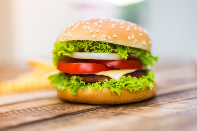 Foto gratuita hamburguesa con queso apetitosa sobre mesa de madera