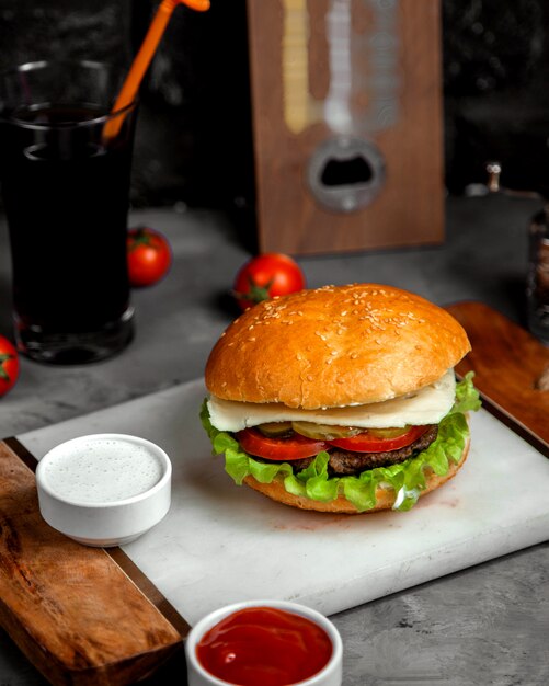 Foto gratuita hamburguesa con queso y carne con pepinillos y tomates