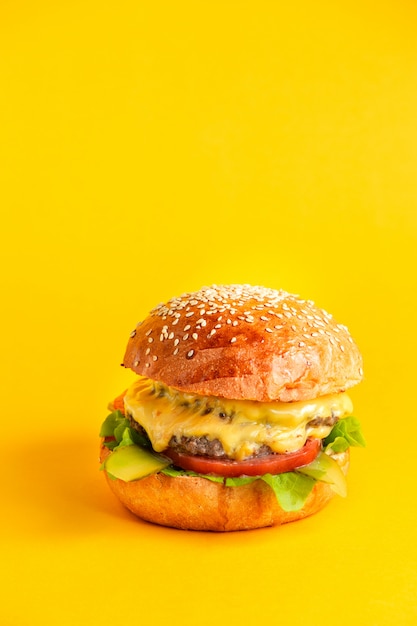 hamburguesa con queso con doble empanada de carne de res y salsa de hojas de lechuga con tomate y queso y pepino en vinagre en bollos de hamburguesa