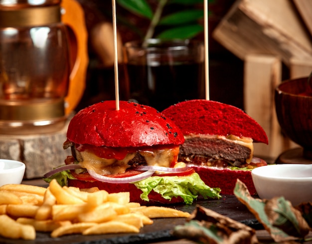 Hamburguesa con queso con pan rojo y papas fritas