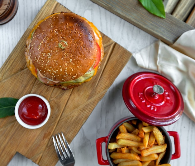 Hamburguesa con queso con papas fritas y salsa de tomate