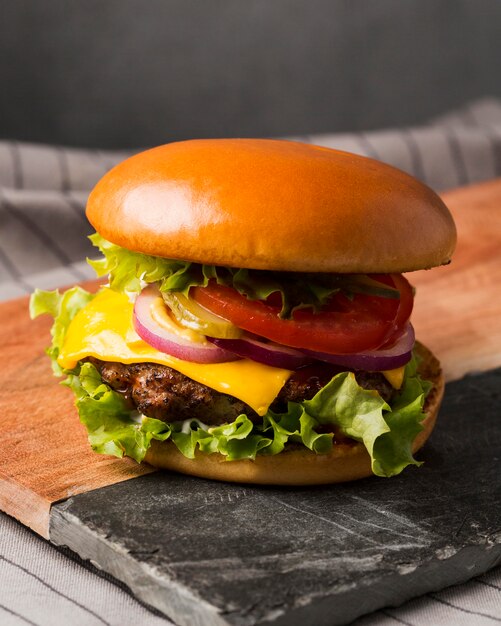 Hamburguesa con queso vista frontal en tabla de cortar