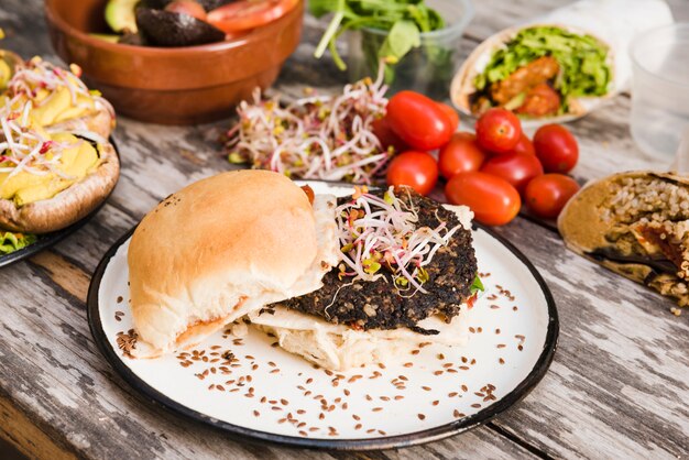 Hamburguesa de quinua vegetariana con brotes y semillas de lino en un plato blanco