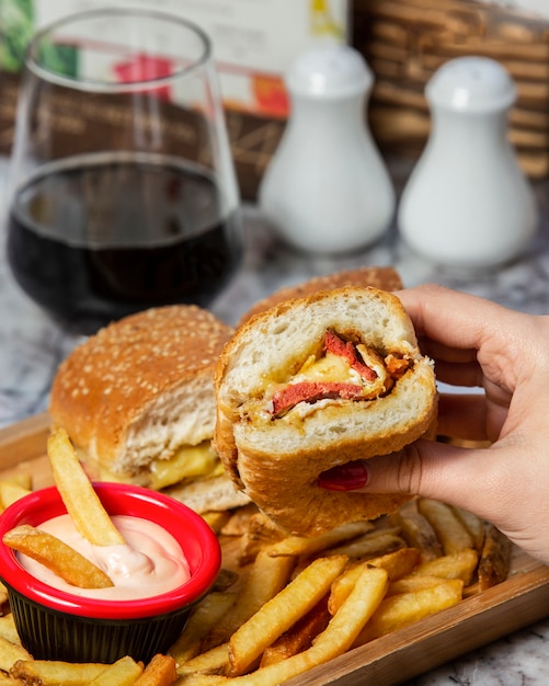 hamburguesa de salchicha con salchicha frita, servida con papas fritas y mayonesa