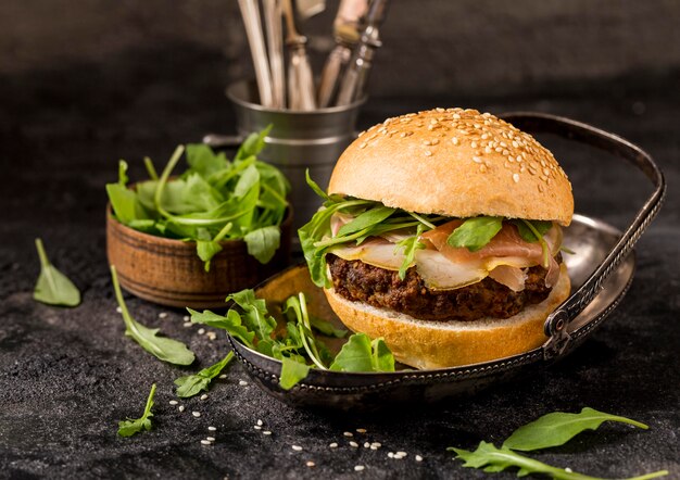 Hamburguesa de ternera de alto ángulo con ensalada y tocino