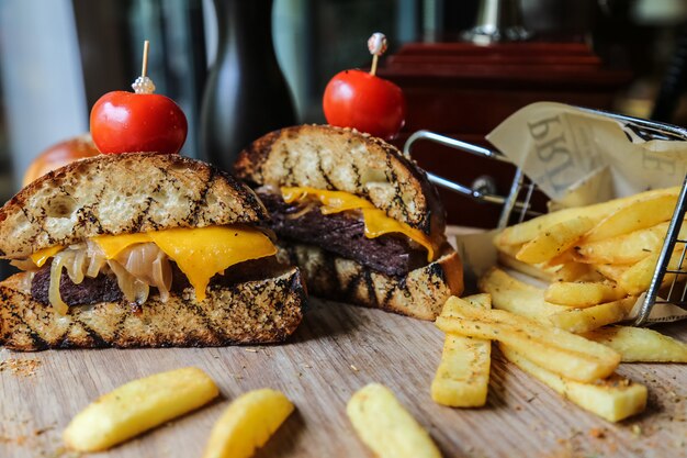 Hamburguesa de ternera cortada en dos trozos con patatas fritas