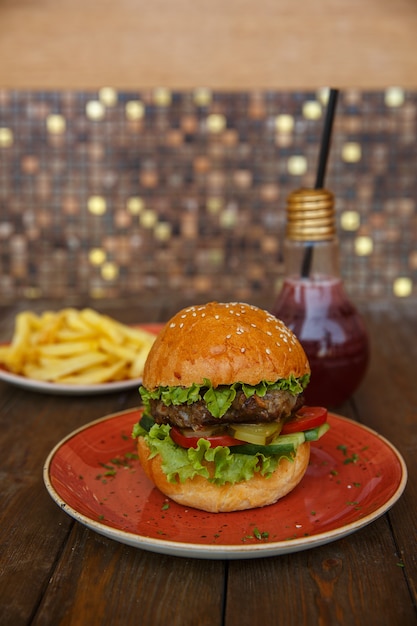 Foto gratuita hamburguesa de ternera con lechuga, pepino fresco y en escabeche, tomate, servido con papas fritas