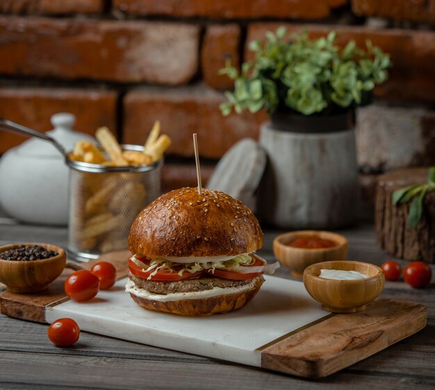 Una hamburguesa de ternera rellena de verduras y aperitivos y servida con hierbas y turshu.