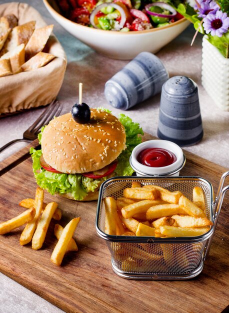 Hamburguesa de ternera servida con canasta de papas fritas