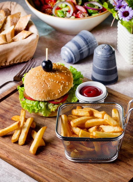 Hamburguesa de ternera servida con canasta de papas fritas