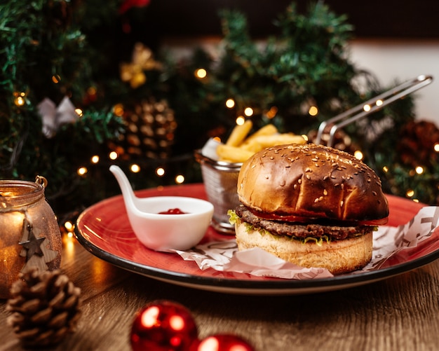 Hamburguesa de ternera servida con papas fritas y salsa de tomate