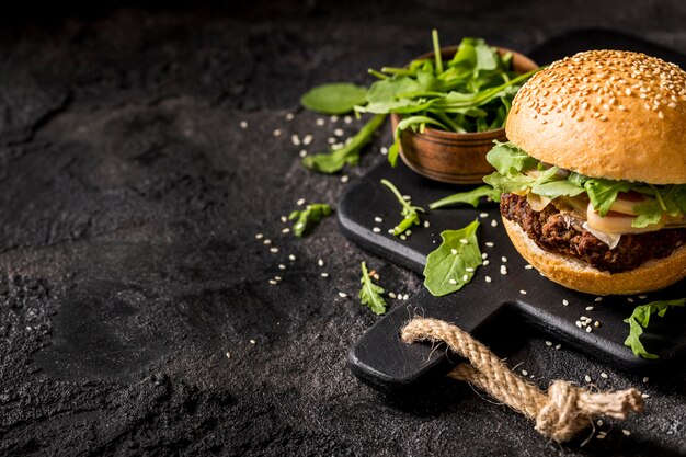 Hamburguesa de tocino de alto ángulo con ensalada y espacio de copia