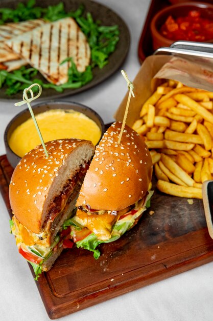 hamburguesa con tomate lechuga y queso servido con papas fritas