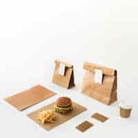 Foto gratuita hamburguesa; vaso desechable; papas fritas y paquete de comida aislado sobre fondo blanco