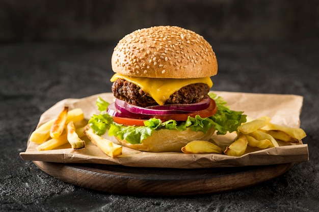 Hamburguesa de vista frontal y papas fritas en placa