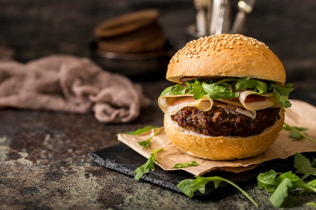 Hamburguesa de vista frontal con tocino en tablero de pizarra